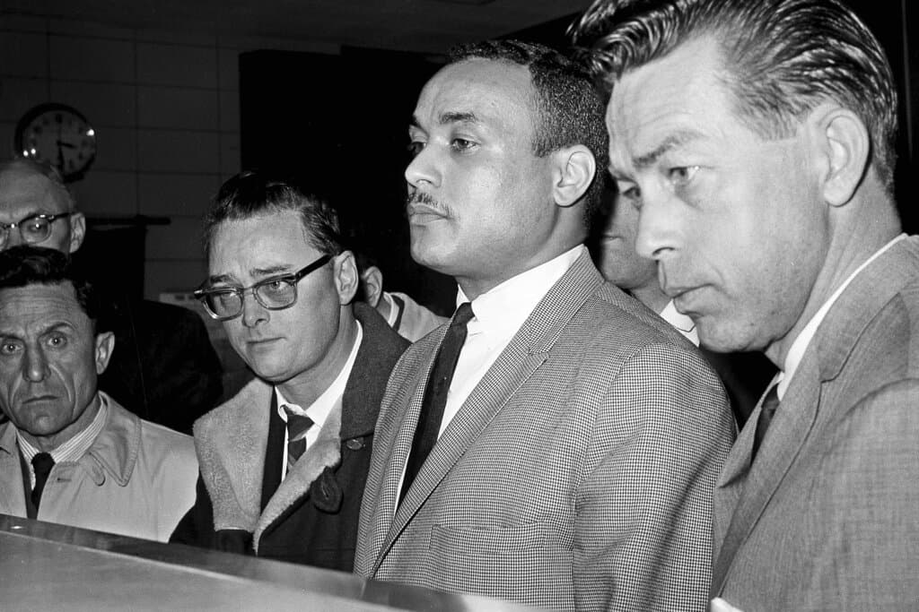 ARCHIVO- Thomas 15X Johnson, en el centro, fue registrado como el tercer sospechoso en el asesinato de Malcolm X, en Nueva York, el 3 de marzo de 1965.
