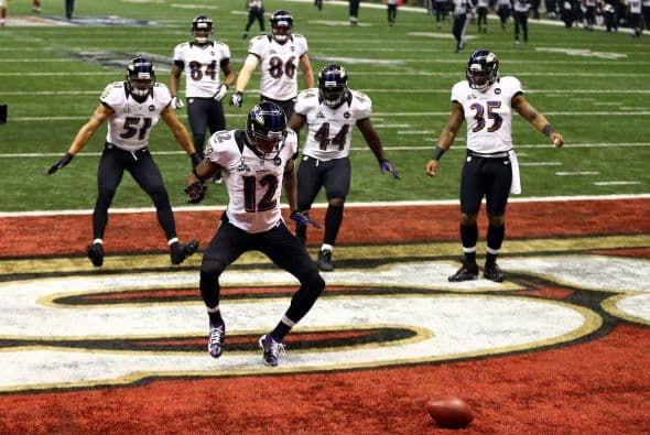 La gran fiesta deportiva del año en Estados Unidos, el Super Bowl de la Liga Nacional de Fútbol Americano (NFL), en su cuadragésima séptima edición, ya forma parte de la historia con los Ravens de Baltimore como nuevos campeones al vencer por 34-31 a los 49ers de San Francisco. Los pronósticos se cumplieron, los Ravens llegaron al Mercedes-Benz Super Dome de Nueva Orleans con el mejor mariscal de campo del momento, Joe Flacco, y la mejor defensa de la NFL, ambos factores se hicieron presentes en los momentos decisivos que hicieron posible el triunfo y el conseguir el segundo trofeo Vince Lombardi en la historia de la franquicia de Baltimore. Flacco, de 28 años, fue el líder perfecto en la primera parte al conseguir tres pases de anotación, que lo dejaron como el sexto mariscal que lo consigue en la historia del Super Bowl y una ventaja parcial de 21-6 al descanso que sería decisiva. El safety Ed Reed, nativo de New Orleans, empataría la mejor marca de la fase final de la NFL con nueve robos aéreos, mientras que Kaepernick quedaría con la mancha de la interceptación que sufrió. Antes que se diese el ya histórico apagón, el primero en un Super Bowl, el receptor abierto Jacoby Jones también quiso entrar en los libros de las marcas al conseguir nada más comenzar el tercer periodo al regresar 108 yardas de "touchdown" una devolución de balón, la mejor de todos los tiempos. Kaepernick y los 49ers vivieron los momentos estelares del partido al conseguir 23 puntos en menos de 13 minutos, 17 fueron consecutivos. Lewis, no brilló como en el primer Super Bowl del 2001 cuando ganó el premio de Jugador Más Valioso (MVP), que esta vez le fue con todos los honores a Flacco, al completar 22 de 33 pases para 287 yardas, sin interceptaciones, pero hizo seis derribos y cuatro fueron "placajes" solitarios. Suficientes para que los Ravens lograsen el segundo trofeo Vince Lombardi en su historia y Lewis pudiese cerrar con broche de oro su legado de 17 temporadas brillantes dentro de la competición de la NFL. Mientras que la revelación de la temporada Kaepernick confirmó que es un mariscal muy especial, lleno de energía, que corre como nadie, que tiene un dinamismo único, pero que todavía no pudo emular a los legendarios Montana y Young, que lo precedieron al frente de los 49ers en los cinco Super Bowls que disputaron y que consiguieron ganar. Los jugadores de los 49er, encabezados por el corredor Frank Gore insistieron que su equipo fue mejor como conjunto que los Ravens se aprovecharon de acciones aisladas. Pero el marcador final estableció que los ganadores fueron los Ravens, por eso dos hermanos, John y Jim Harbaugh, los primeros en la historia de la NFL que dirigieron a los equipos que disputaron un título de Super Bowl, al concluir el partido fueron al encuentro y se dieron un gran abrazo.