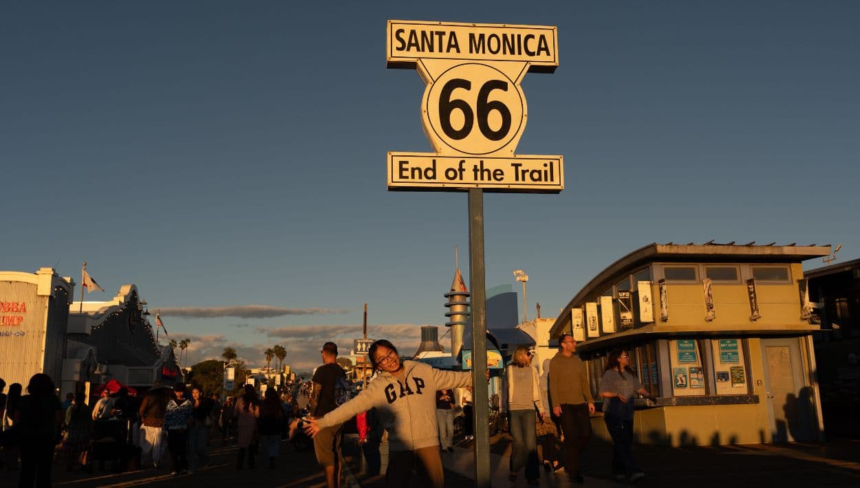 Una visitante posa para fotos junto al letrero de “End of the Trail” de la Ruta 66 en el muelle de Santa Mónica, en Santa Mónica, California.
