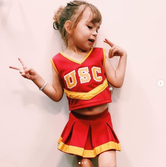 A Michelle le encanta posar para las fotos y con su personalidad acapara las cámaras de sus papis y sus hermanos. Vestida de porrista, hace casi dos años, visitó a su hermana mayor, Hannah, en su universidad en California.