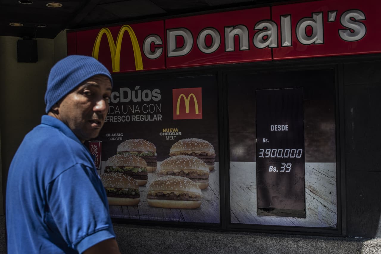 Críticos y analistas citados por la agencia Reuters sostienen que las medidas no resolverán la agobiante hiperinflación, que según el Fondo Monetario Internacional (FMI) podría sumar una escalada histórica de 1,000,000% al año. En la fotografía la fachada de un restaurante McDonalds en Caracas, que ofrece un producto por 3,900,000 Bolívares fuertes, o 39 de los nuevos bolívares soberanos.
