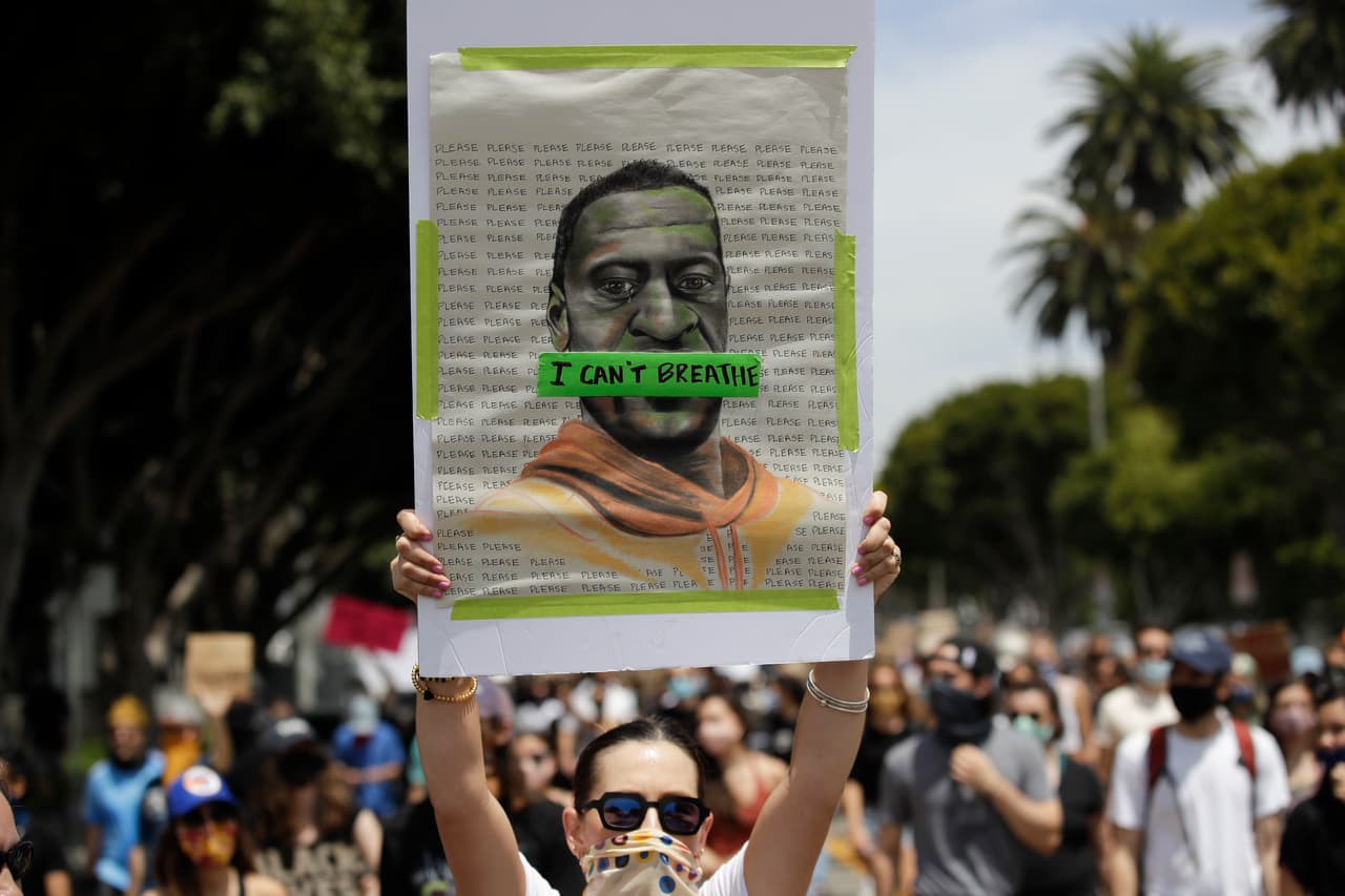 Una mujer sostiene un cartel con la imagen de George Floyd este martes al mediodía (hora local) en el distrito de Venice en Los Ángeles, California.