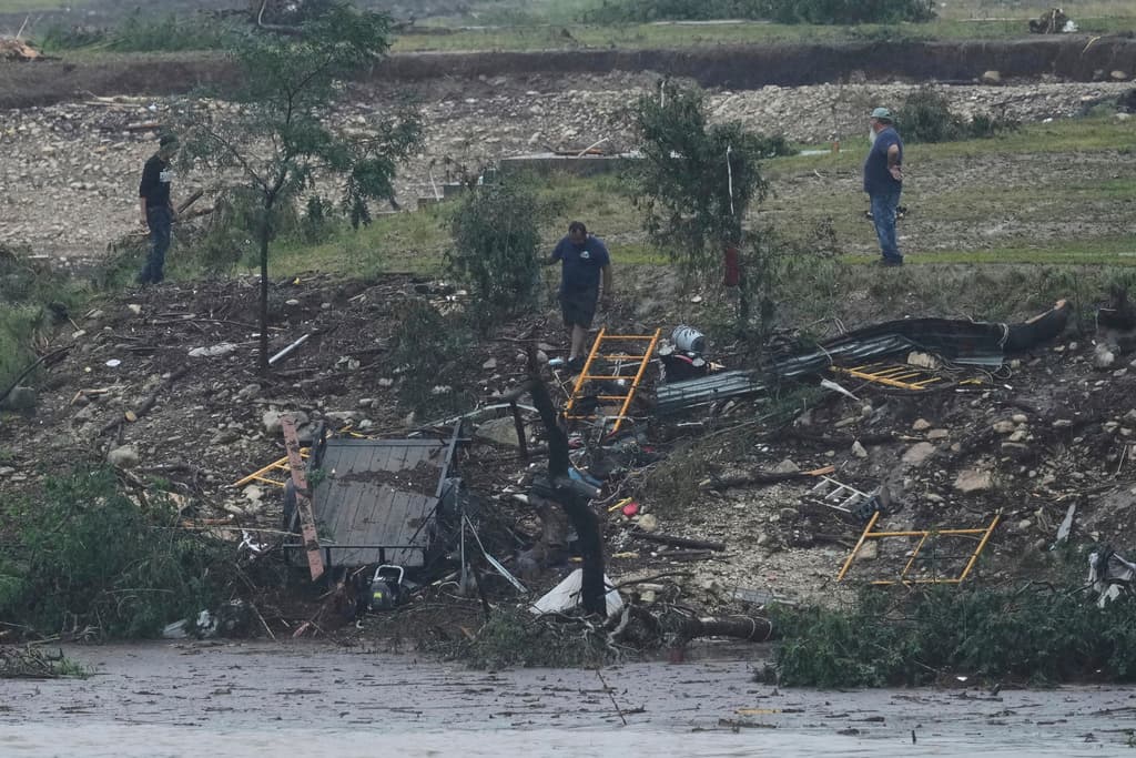 Varios hombres inspeccionan los daños causados por el caudaloso río Guadalupe, el viernes 4 de julio de 2025, en Kerrville, Texas.