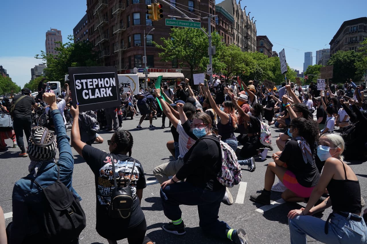 Los manifestantes congregados en el boulevard Adam Clayton Powell, Jr. de Nueva York hincan una rodilla para honrar la memoria de George Floyd.