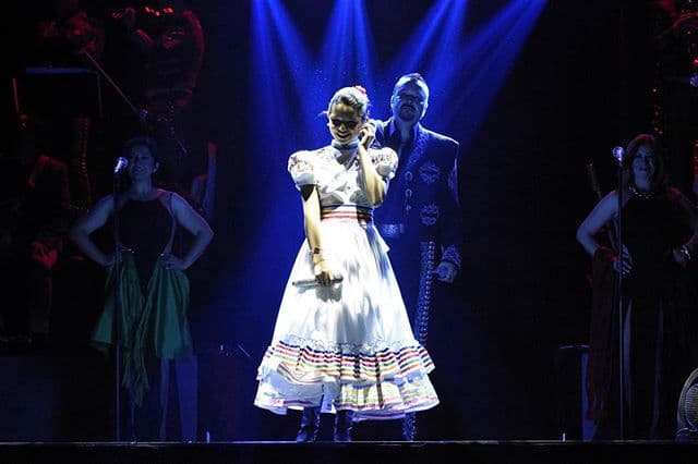 Utilizando hermosos vestidos bordados a mano por verdaderos artesanos.