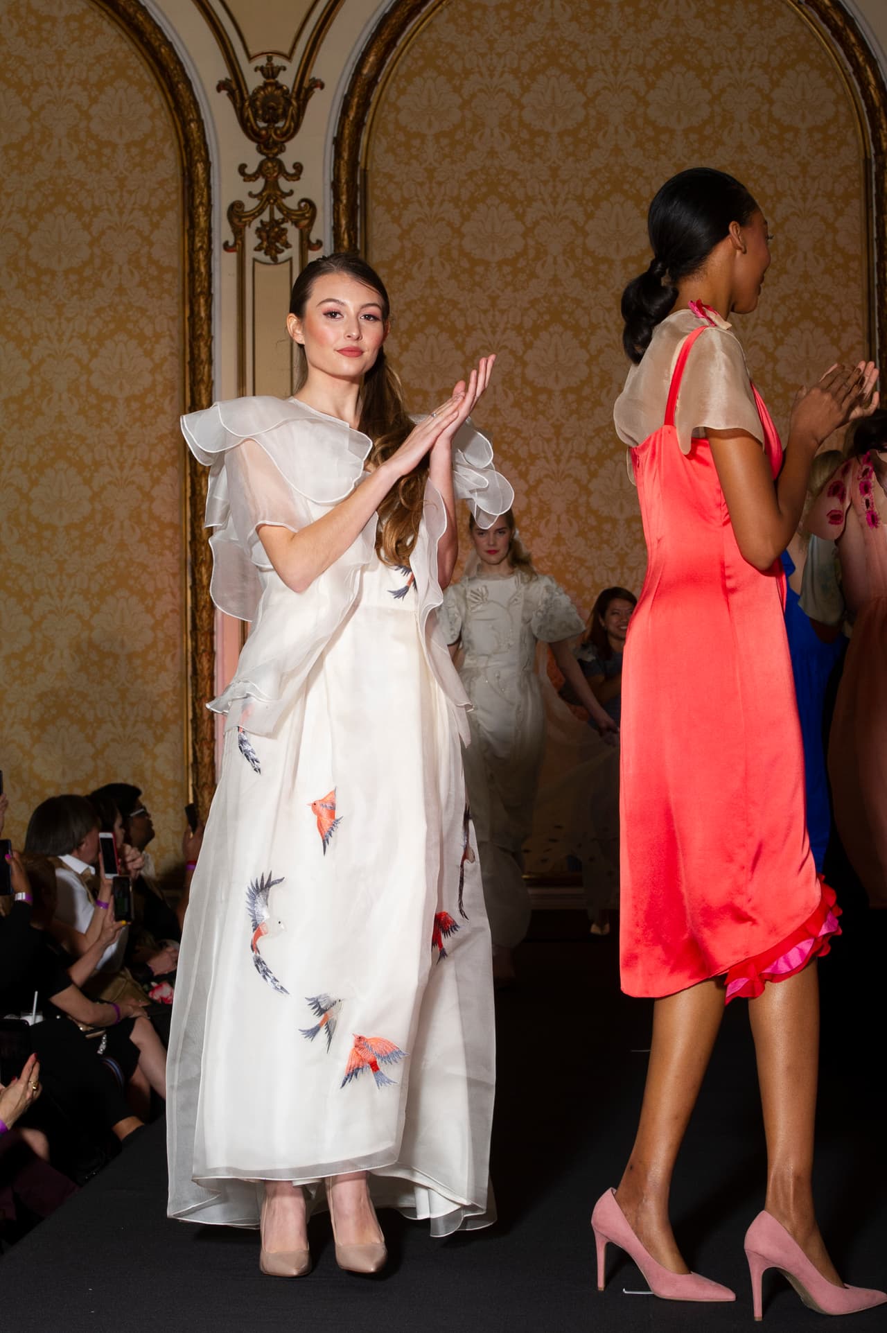 Las modelos al final de su desfile aplauden.