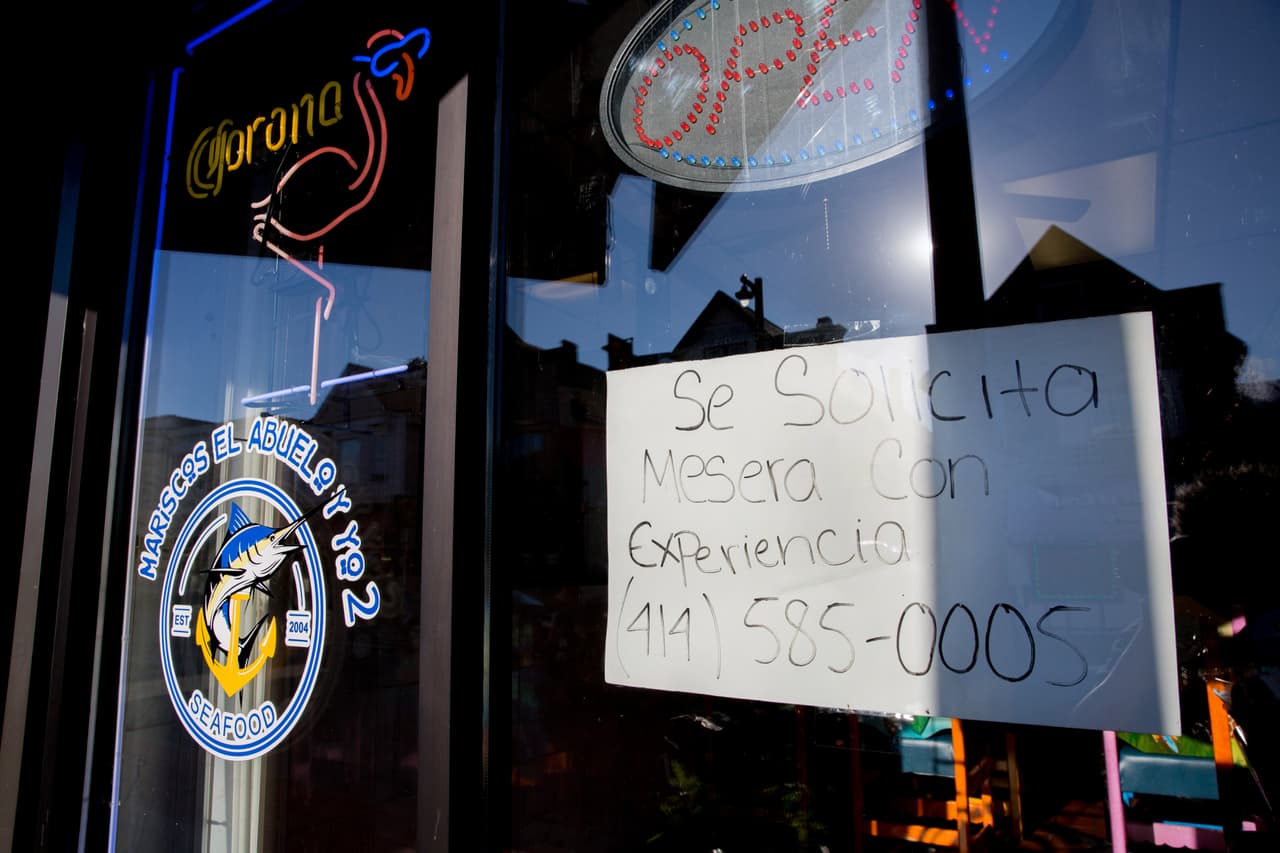 Un anuncio en español ofrece trabajo en uno de los negocios de la calle César Chávez.
