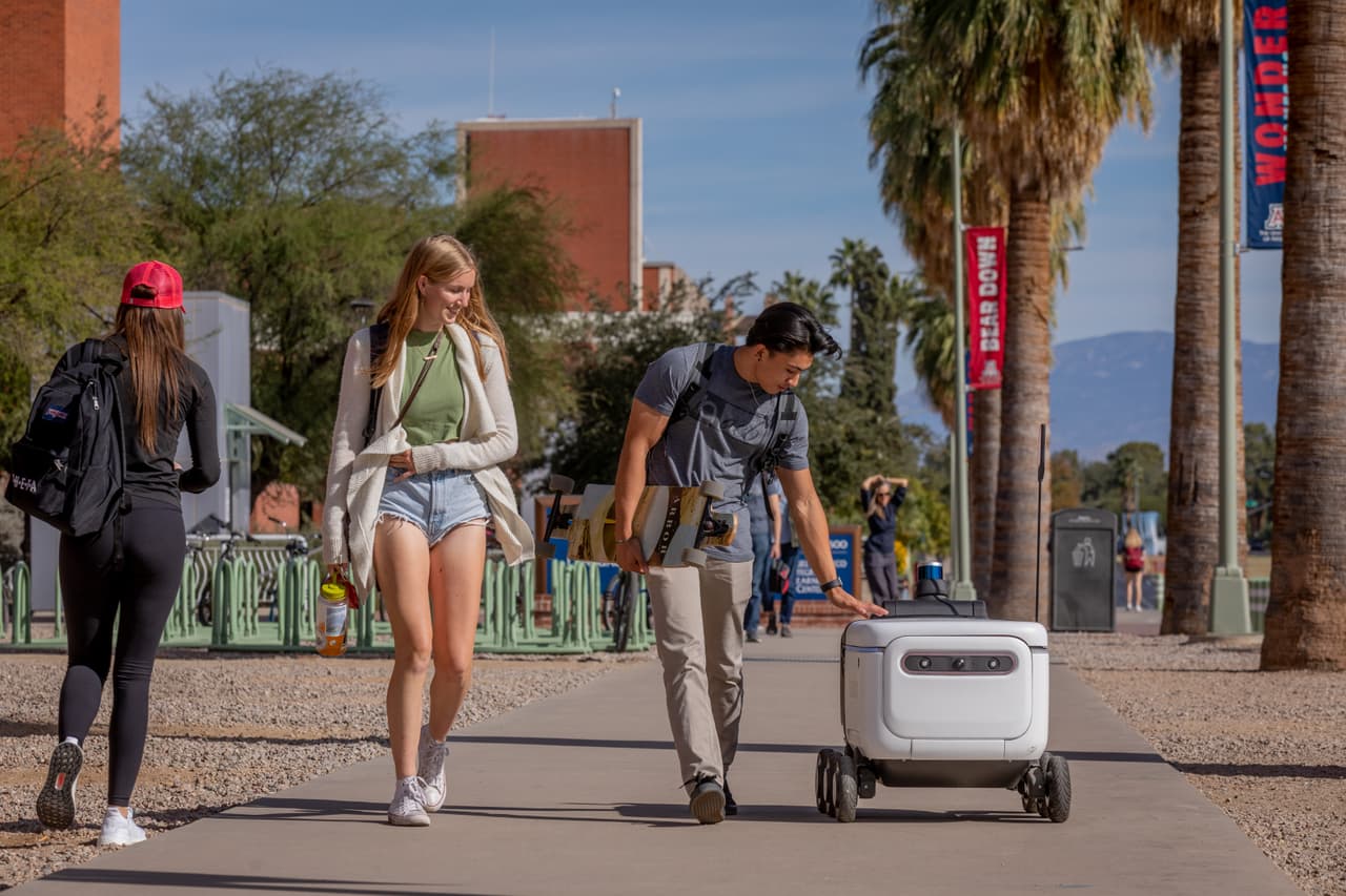 Los robots rodantes estarán sirviendo al campus de la 
<a href="https://www.arizona.edu/admissions?gclid=CjwKCAiA7dKMBhBCEiwAO_crFEmKOkFjZNQX2RZGJwqBDSC9TiSGJXdBD4Er9kKnl7AIH2NMXqyydRoCBgYQAvD_BwE" target="_blank">Universidad de Arizona</a> gracias a la asociación entre los 
<i>Sindicatos de Estudiantes de Arizona</i> y Grubhub, detalla un comunicado de UArizona. Estos robots empiezan sus labores de entrega a partir de este miércoles 17 de noviembre.