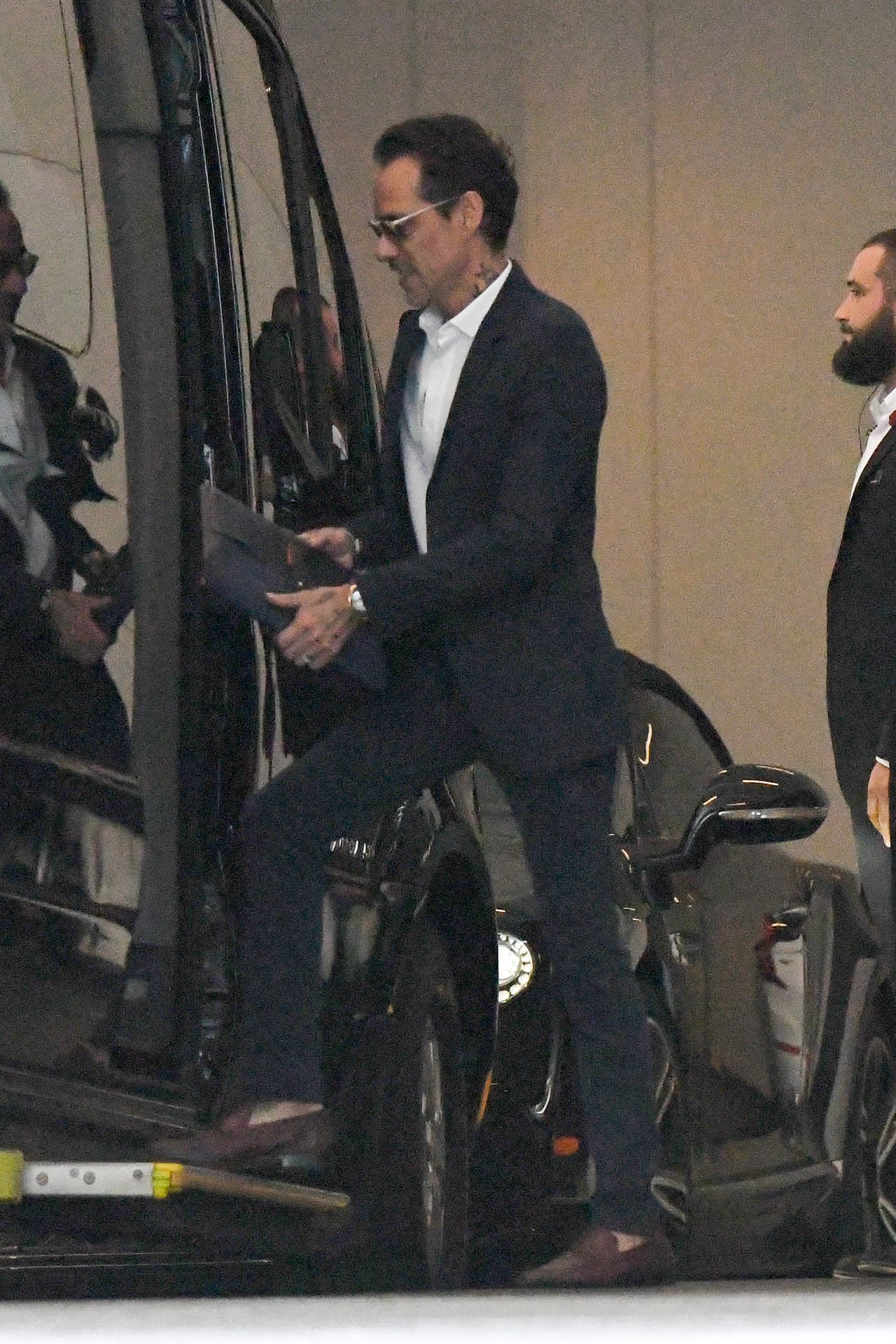 En las manos cargaba un organizador estilo carpeta aparentemente de piel.