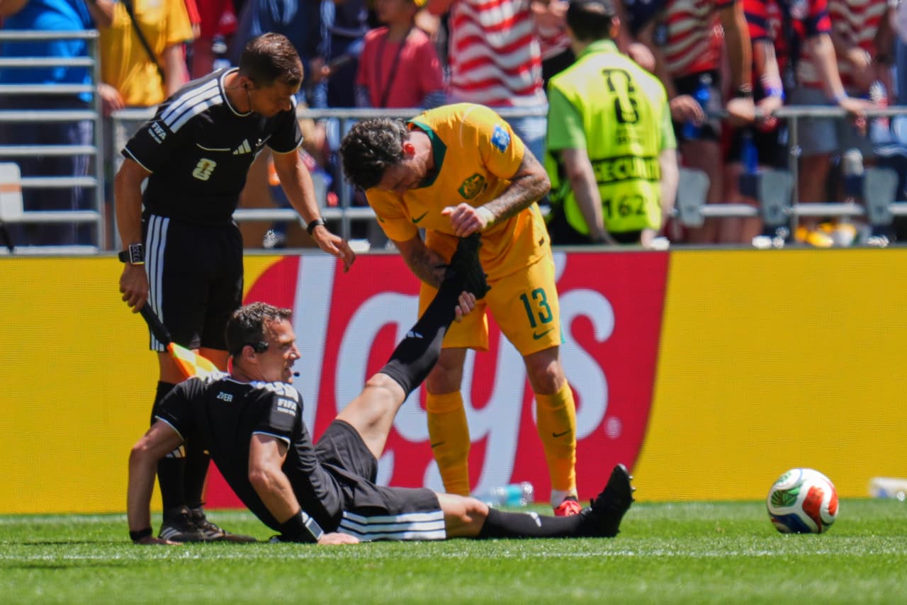 El árbitro alemán Felix Zwayer es asistido por el australiano Aiden O'Neill (13) durante el partido del Grupo D de la Copa Mundial entre Estados Unidos y Australia en Seattle, el viernes 19 de junio de 2026.