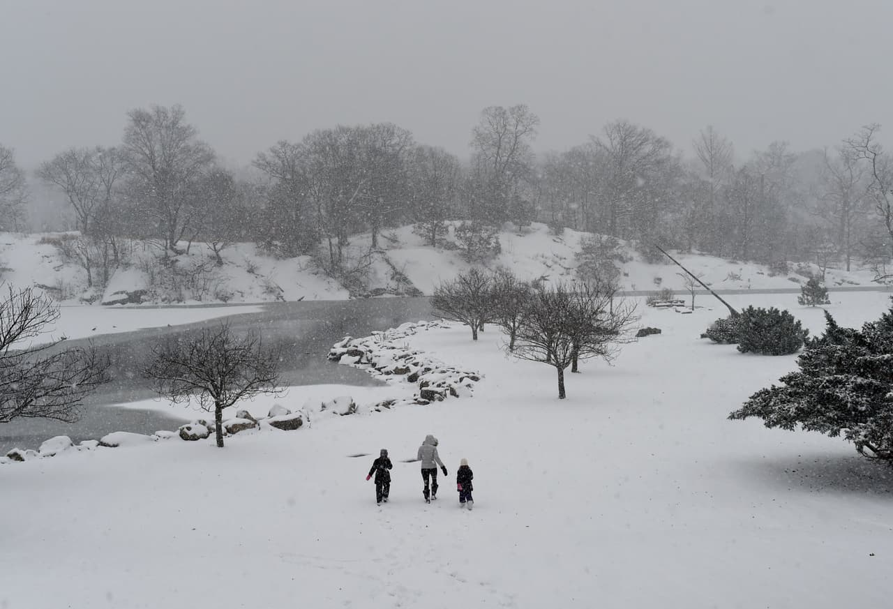 Una familia camina a través de la nieve en el parque Bruce Park de Greenwich, Connecticut. Las temperaturas han alcanzado allí los 29 grados Fahrenheit (-2C).