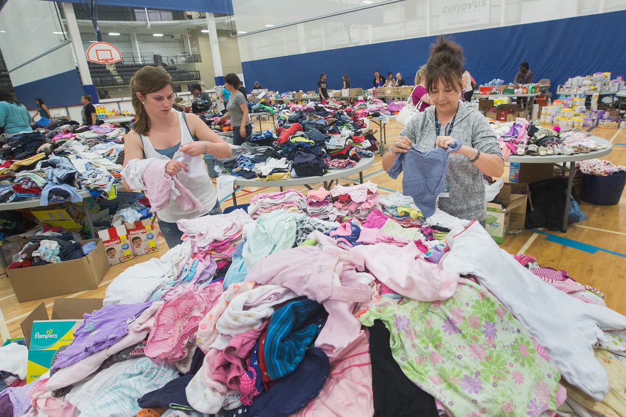 Los evacuados buscan ropa entre centenares de piezas donadas.
