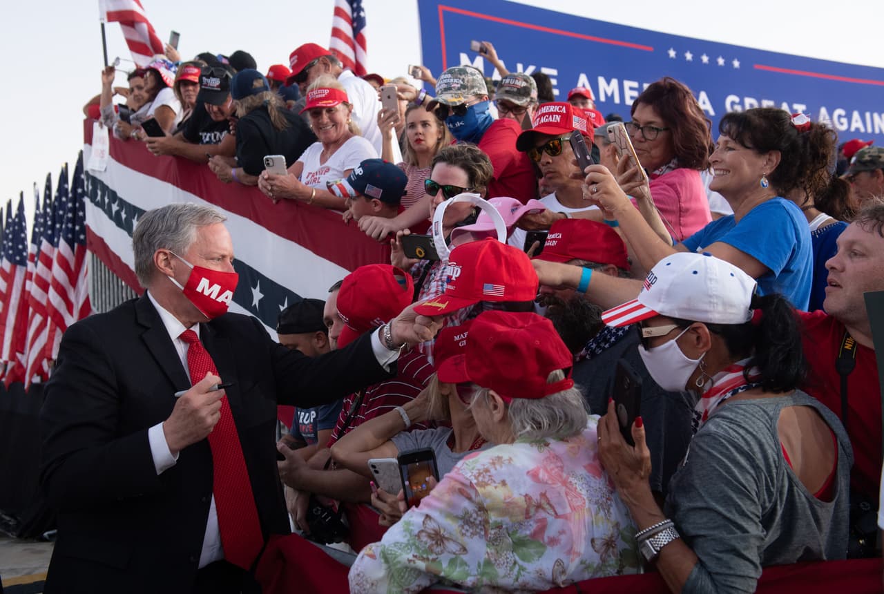 El Jefe de Gabinete de la Casa Blanca, Mark Meadows, firma sombreros durante el mitin Make America Great Again en el Aeropuerto Internacional Orlando Sanford en Sanford, Florida.