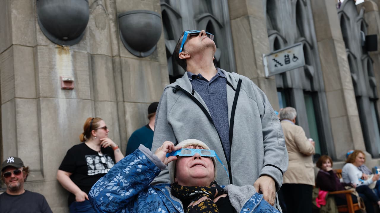 Transeuntes en la ciudad de Nueva York se detienen para ver el desarrollo del eclipse solar el lunes 8 de abril de 2024.