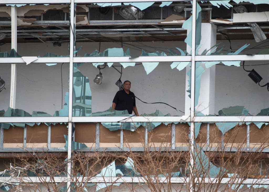 Un hombre observa desde el interior del edificio los daños producidos por el huracán.