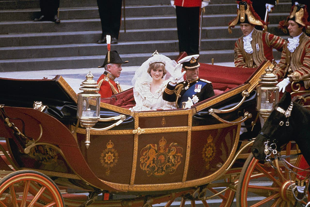 Carlos y Diana, ya convertida en princesa de Gales tras la ceremonia de casamiento, abordan el carruaje que los llevaría al Palacio de Buckingham, residencia oficial de la reina Isabel II y sede de la Casa Real británica, donde se realizó una recepción para 3,500 invitados de todo el mundo.