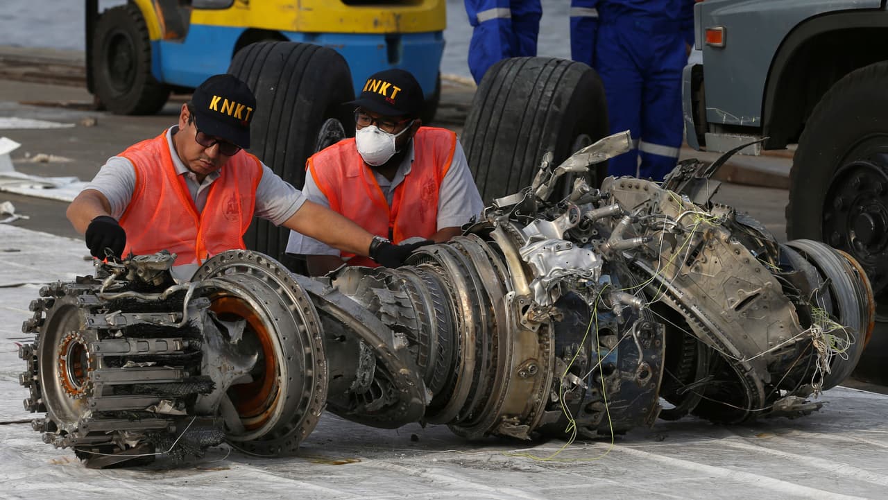 Oficiales inspeccionan un motor recuperado del avión Lion Air.