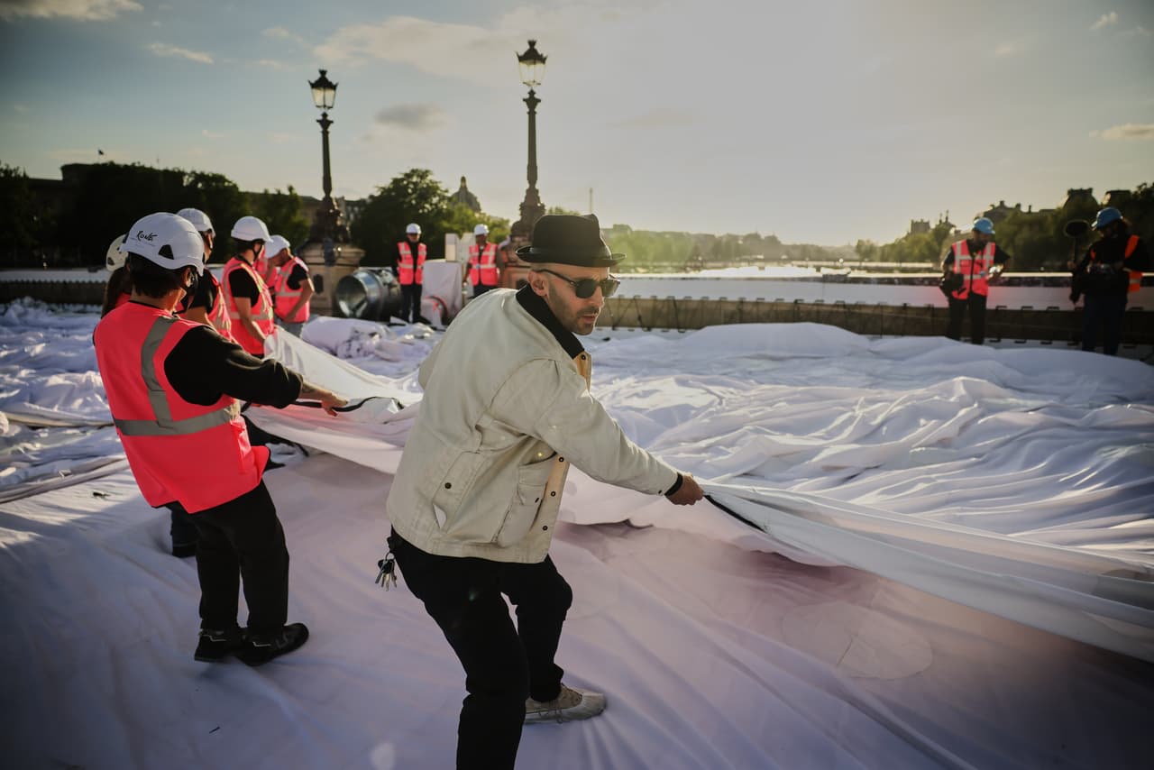 El artista callejero francés JR prepara el inflado de su obra "La cueva del Pont Neuf" en el puente Pont Neuf, el miércoles 20 de mayo de 2026, en París, antes de su inauguración gratuita para el público del 6 al 28 de junio. (Foto AP/Thomas Padilla)