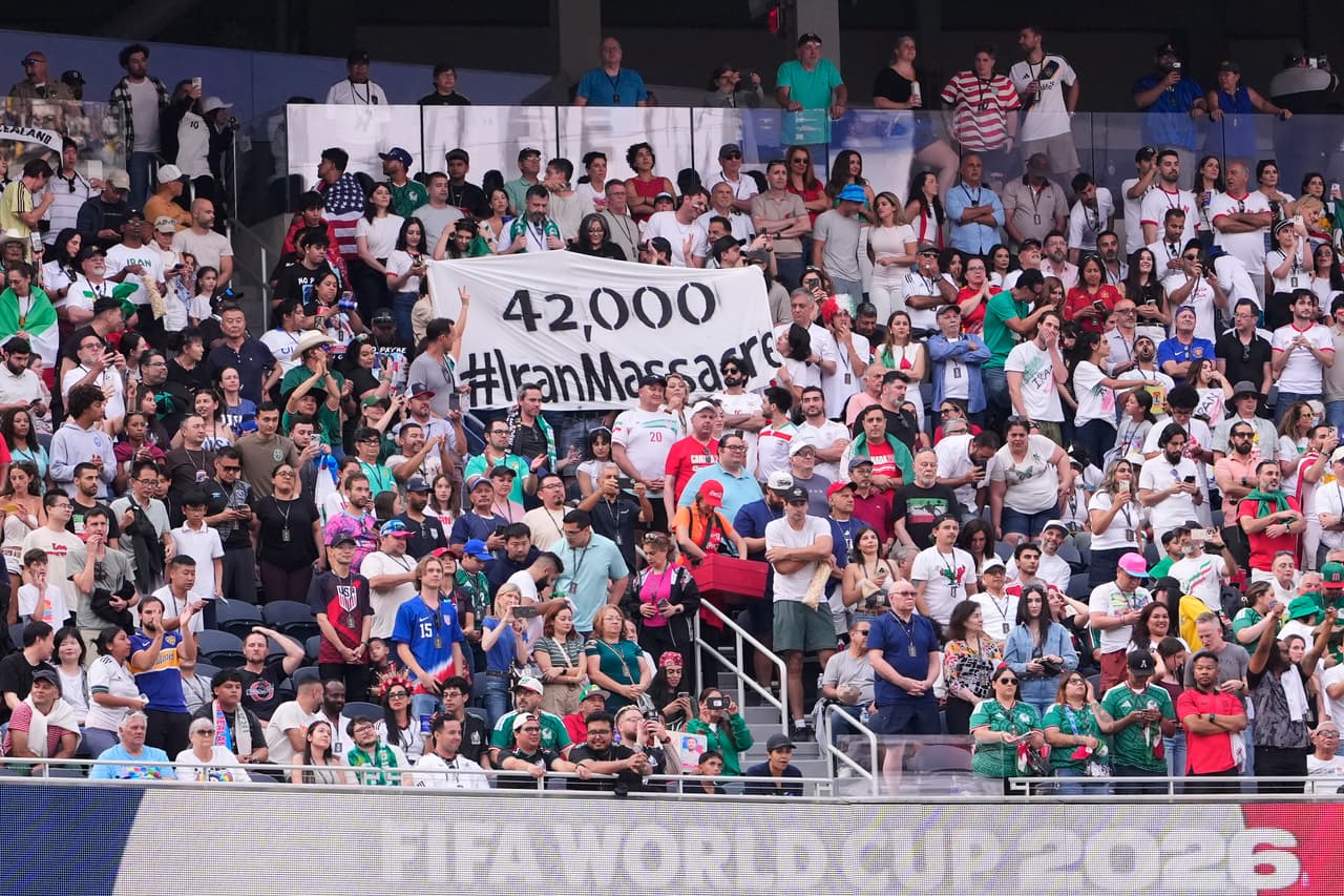 Unos aficionados sostienen una pancarta con el mensaje "42.000 #IranMassacre" durante el partido de fútbol del Grupo G de la Copa del Mundo entre Irán y Nueva Zelanda.