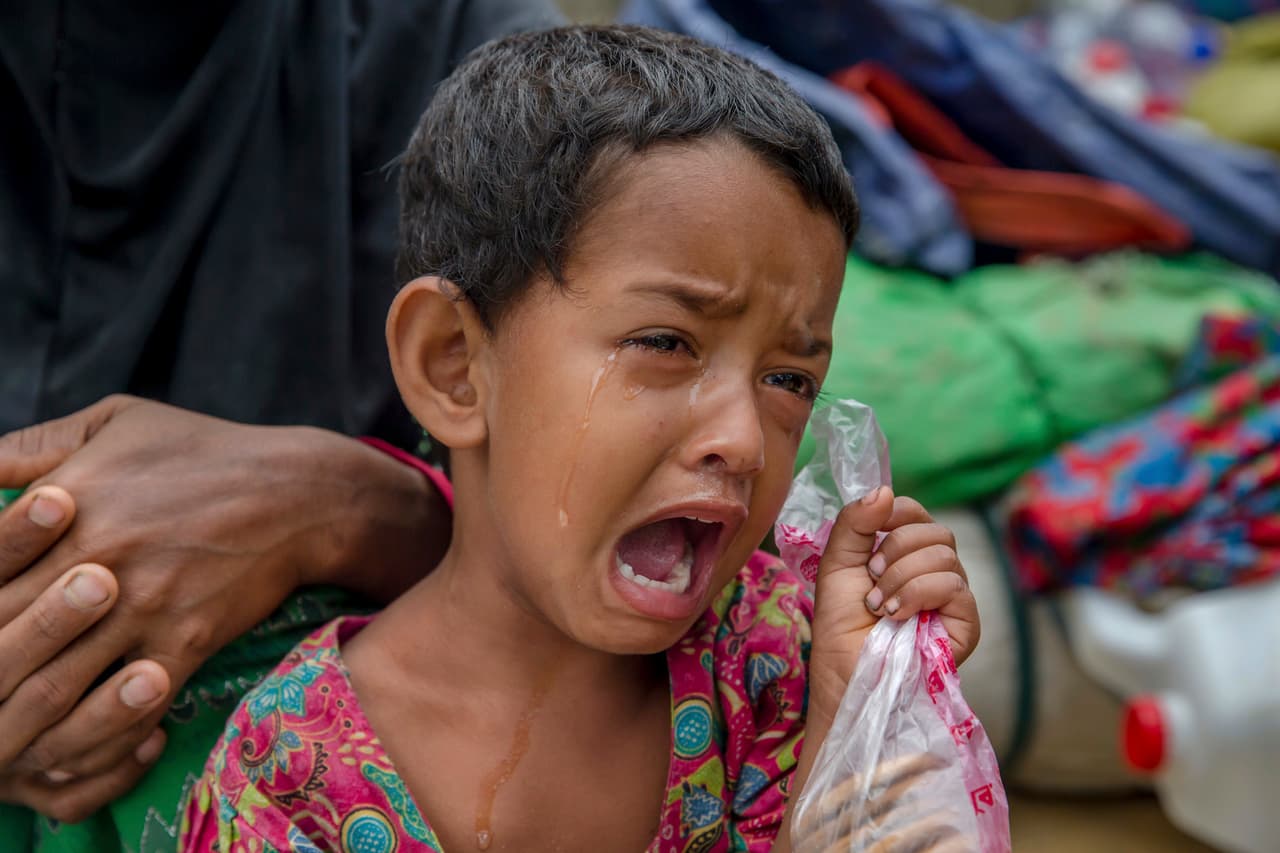 La niña rohingya Toyiba Khatun llora por la fiebre mientras espera junto a su familia para registrarse en el campo de refugiados de Kutupalong, Bangladesh. Según la Organización Mundial de la salud, más del 60% del agua en los campamentos está contaminada con bacterias de los sanitarios temporales.