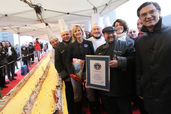 El presidente del Consejo Guinness Justine Bourdariat, posa con el chef francés Philippe Gardette a lado del tronco navideño (platillo típico) más largo del mundo 492.125 pies (150 metros) en diciembre de 2010 en el mercado de Navidad en La Defense, en las afueras de París.