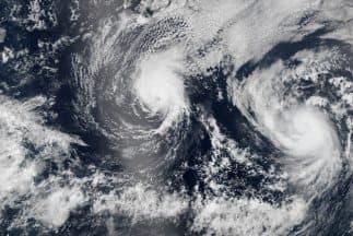 El primero de dos sistemas consecutivos sobre Hawai tocó tierra como una debilitada tormenta tropical. Un segundo sistema también se debilitó e iba en camino a pasar muy al norte de las islas el domingo.