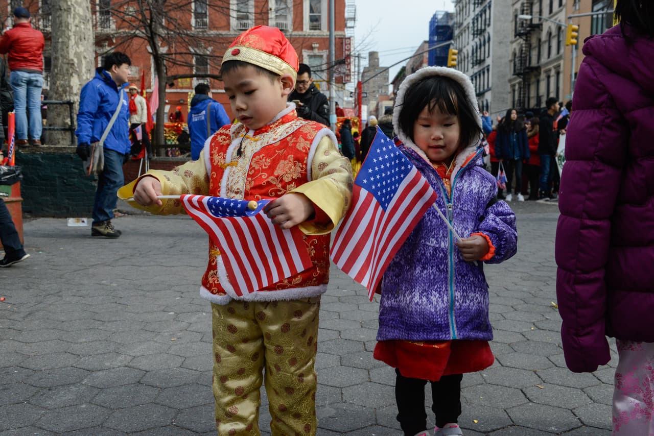 Los niños caminan con banderas de Estados Unidos mientras que asisten al desfile lunar chino.