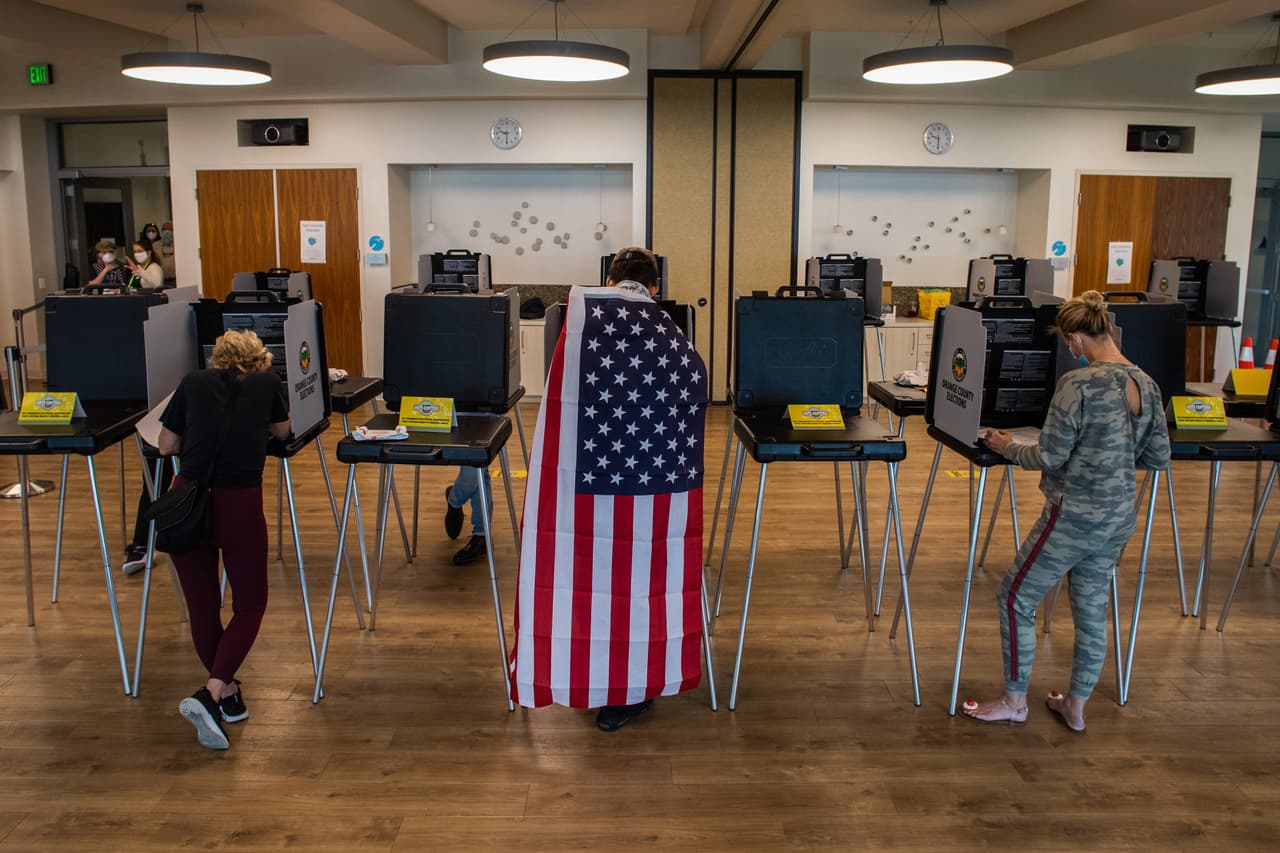 David Boston asiste a votar al Centro Comunitario Marina Park, en Newport Beach, California. Boston llevó una bandera de Estados Unidos en su espalda en un día histórico para el país, donde en días previos votaron más de 100 millones de personas.