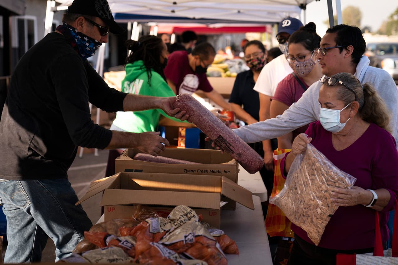 <b>Cada vez más personas en las filas.</b> En Los Ángeles, los voluntarios estimaron que más de 1,000 personas hicieron fila
<a href="https://www.cnn.com/videos/us/2020/11/21/coronavirus-pandemic-food-bank-los-angeles-holiday-vercammen-nr-vpx.cnn"><u> el sábado frente a un banco de alimentos</u></a>, según CNN, un hecho inédito. En la foto una entrega de alimentos en la Iglesia Pentecostal Internacional en Bellflower, California, el 11 de noviembre.