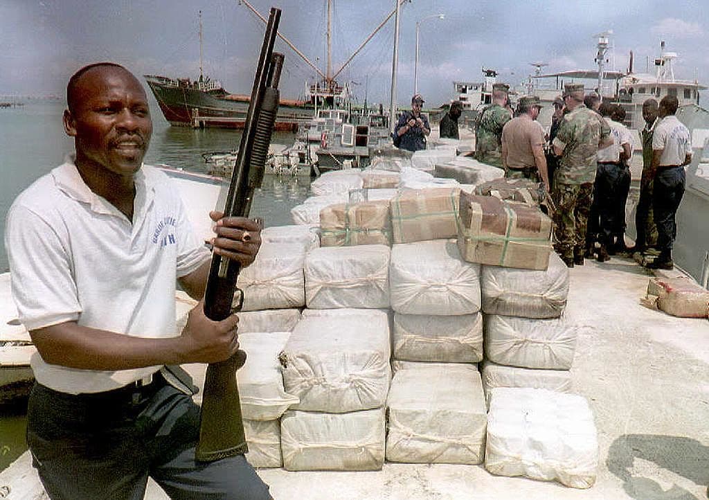 A Haitian Coast Guard officer, on a Port-au-Prince dock, guards cocaine and marijuana confiscated 22 March,1997. The drugs were confiscated in the southeastern port of Jacmel from a boat that arrived from Colombia.