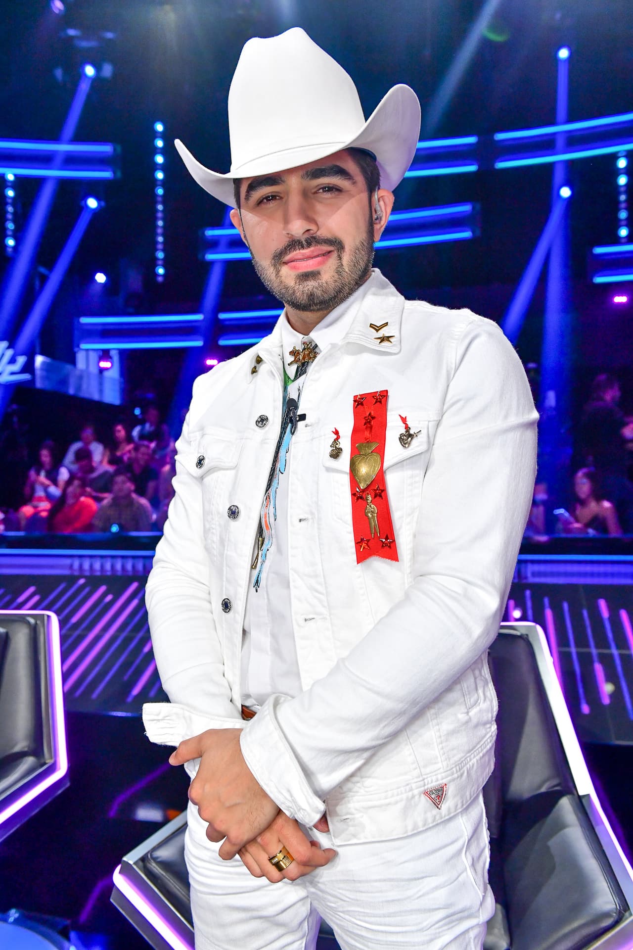 Joss Favela eligió el blanco de pies a cabeza para esta sesión de Reina de la Canción. Con una chaqueta Guess, una camisa Givenchy y jeans Dsquared2, 'El lujo de Sinaloa' sorprendió a todos por lo monocromático del atuendo.