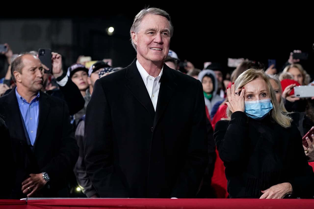 El senador republicano David Perdue escucha mientras el presidente Donald Trump habla durante un mitin de campaña para los candidatos republicanos en el Aeropuerto Regional de Valdosta en Georgia. Perdue ha sido un fiel aliado de Trump y apoya su pelea para revocar la elección del presidente electo Joe Biden.