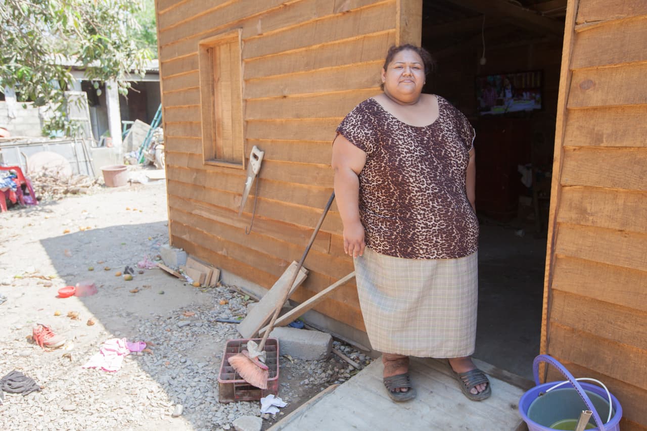 El hermano enfermo de Grisel reposa en un refugio temporal de madera que una organización no gubernamental, Catholic Relief Services, le construyó junto a las ruinas de su antigua casa. Los demás familiares duermen entre el patio y la única galera que quedó en pie.