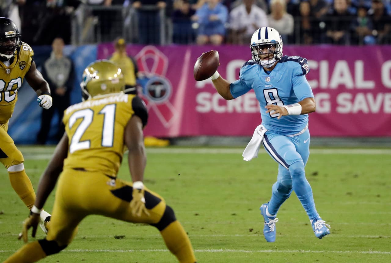 Tennessee Titans quarterback Marcus Mariota (8) scrambles as he is defended by Jacksonville Jaguars defensive tackle Malik Jackson (90) and cornerback Prince Amukamara (21) in the first half of an NFL football game Thursday, Oct. 27, 2016, in Nashville, Tenn. (AP Photo/James Kenney)