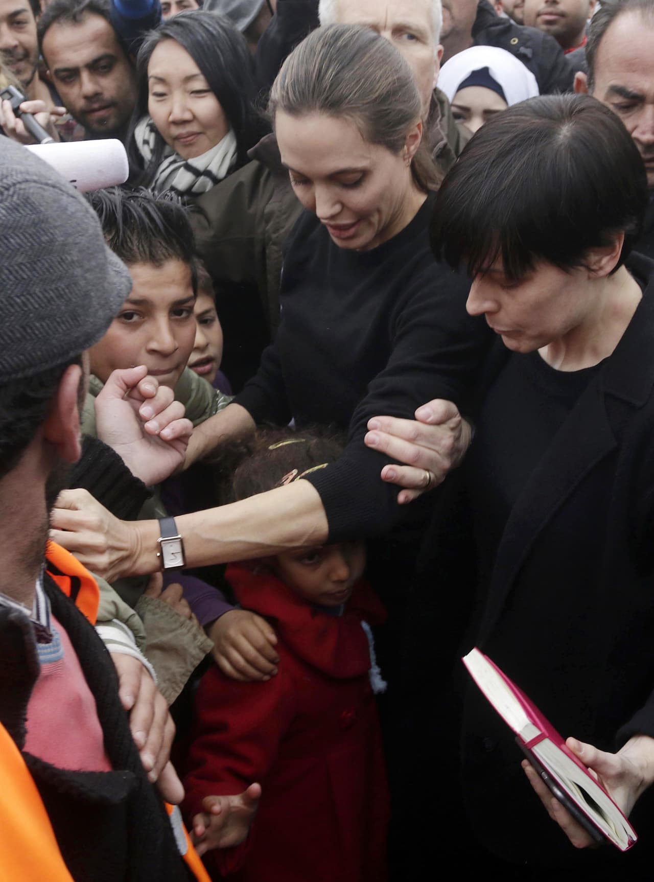 Refugiados y periodistas empujaban, Angelina intentaba resguardarse y proteger a la niña que le hizo el regalo.