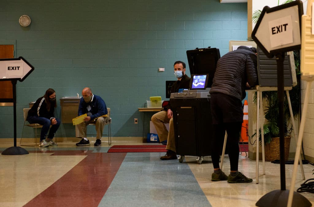 En un colegio de Fayetteville, varios voluntarios asisten a los votantes para aclararles sus dudas y ayudarles en el proceso.