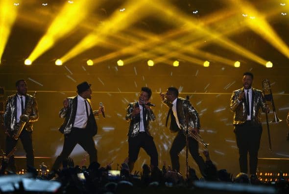Un cuidado estilismo retro, una banda llena de energía y una particular mezcla de soul y rock sirvieron al cantante Bruno Mars para cautivar a la millonaria audiencia del Super Bowl durante el descanso de la gran cita anual del fútbol americano. Mars, de sólo 28 años y sobre quien planeaba la duda de si sería capaz de enfrentarse a un escenario de tal calibre, optó por un show directo y contundente. Tras una breve introducción a cargo de un coro de niños, un espectacular solo de batería sirvió para abrir el fuego y dar paso rápidamente al gran éxito "Locked Out of Heaven". Impecablemente vestido con una chaqueta dorada, despachó el tema junto a una banda con una amplia sección de viento que se lució en las coreografías. Sin más dilación, Mars descargó su segundo hit, "Treasure", y a continuación demostró su capacidad para fusionar el soul, el pop y el rock integrando en su espectáculo a los Red Hot Chili Peppers. La banda de Anthony Kiedis y Flea puso a saltar a todo el estadio Metlife con su clásico "Give it Away". Los rockeros californianos, a pecho descubierto como manda la tradición, solo necesitaron un par de minutos para demostrar que siguen en buena forma y ceder de nuevo el protagonismo a Mars.