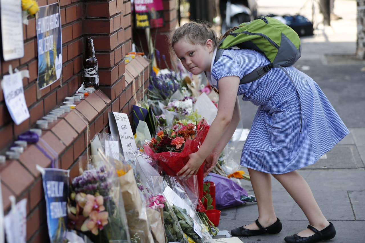 A schoolgirl leaves a bunch of flowers ouside the Finsbury Park Mosque in the Finsbury Park area of north London on June 20, 2017, following a van attack on pedestrians nearby on June 19. Ten people were injured and a man also died at the scene after a van drove into a crowd of Muslim worshippers near a mosque in London in the early hours of Monday. / AFP PHOTO / Tolga AKMEN (Photo credit should read TOLGA AKMEN/AFP/Getty Images)