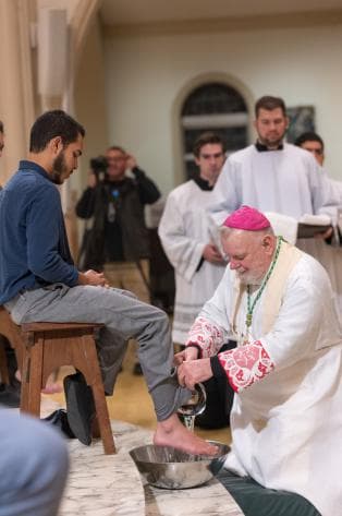 El arzobispo Thomas Wenski lava los pies de Andrés Reyes durante la Misa del Jueves Santo en la Catedral de Saint Mary.
