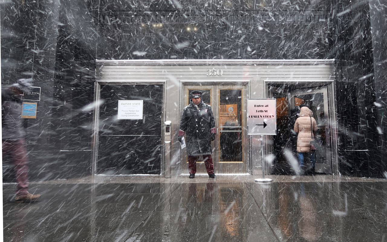 Un portero del edificio Empire State bajo la fuerte nevada.