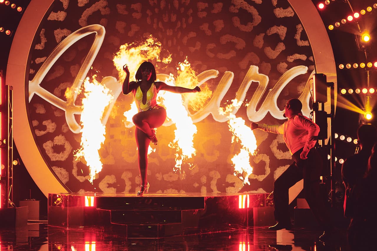 Amara 'La Negra' apareció de entre el fuego y comenzó su rutina de salsa.