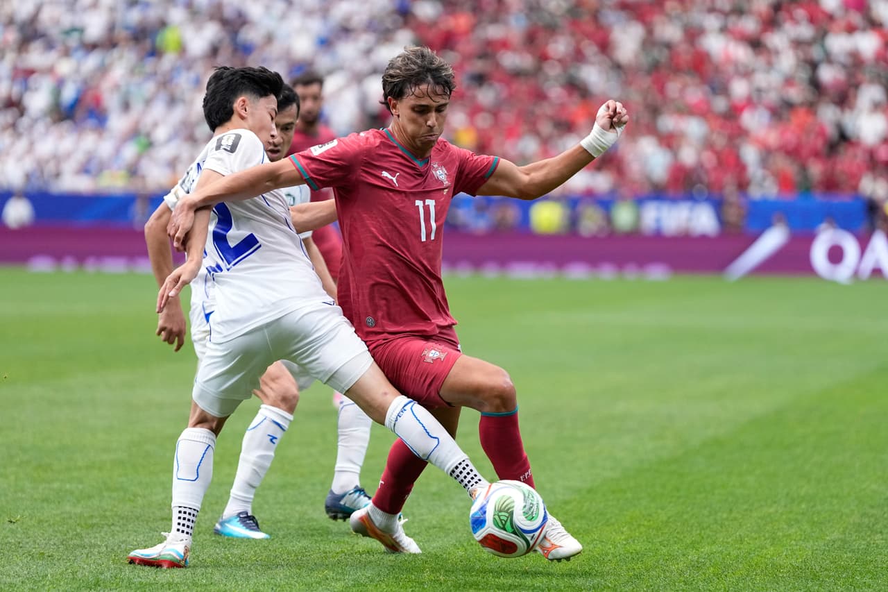 Abbosbek Fayzullaev, de Uzbekistán, disputa el balón con Joao Felix, de Portugal (derecha)