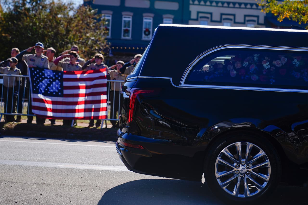 Los boy scouts saludan mientras el coche fúnebre se mueve durante el funeral de la ex primera dama Rosalynn Carter.