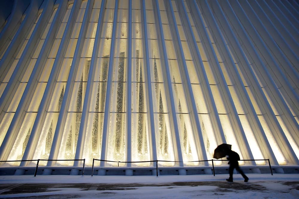 Una persona camina frente a la nueva estación en del World Trade Center cubierto por la nieve.