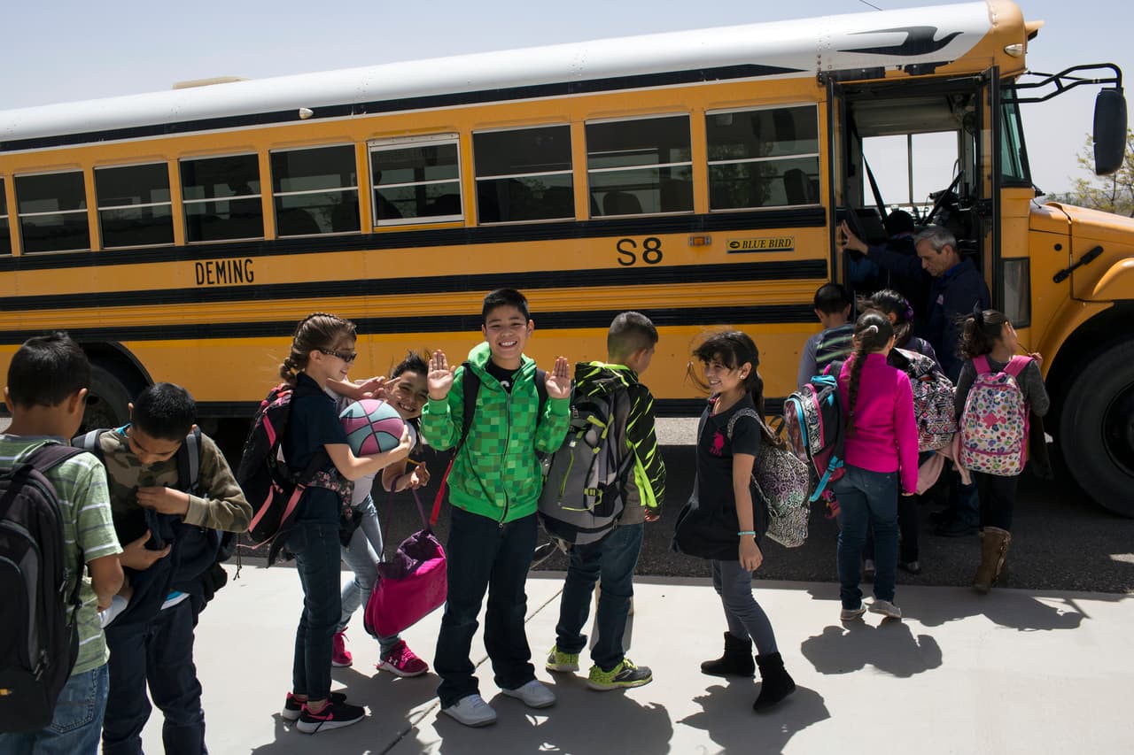 FILE - In this March 31, 2017, file photo, students board a school bus after class at Columbus Elementary School in Columbus, N.M. A high-stakes legal battle focused on the plight of New Mexico's most vulnerable public school students is headed toward an end. After two months of testimony, a state district court judge may reshape the way public schools are funded and guided by the state. Testimony is scheduled to end Friday, Aug. 4, 2017. (AP Photo/Rodrigo Abd, File)