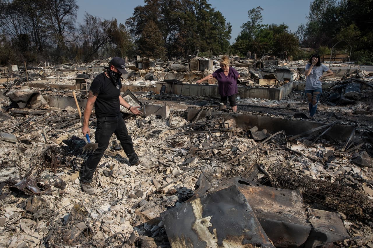 Rob Price ayuda a su madre Yvonne Webber a buscar algunas pertenencias personales entre los escombros de su casa, quemada por el incendio Almeda en Talend, Oregon. Las autoridades reportan al menos tres muertes asociadas a los incendios en el estado.