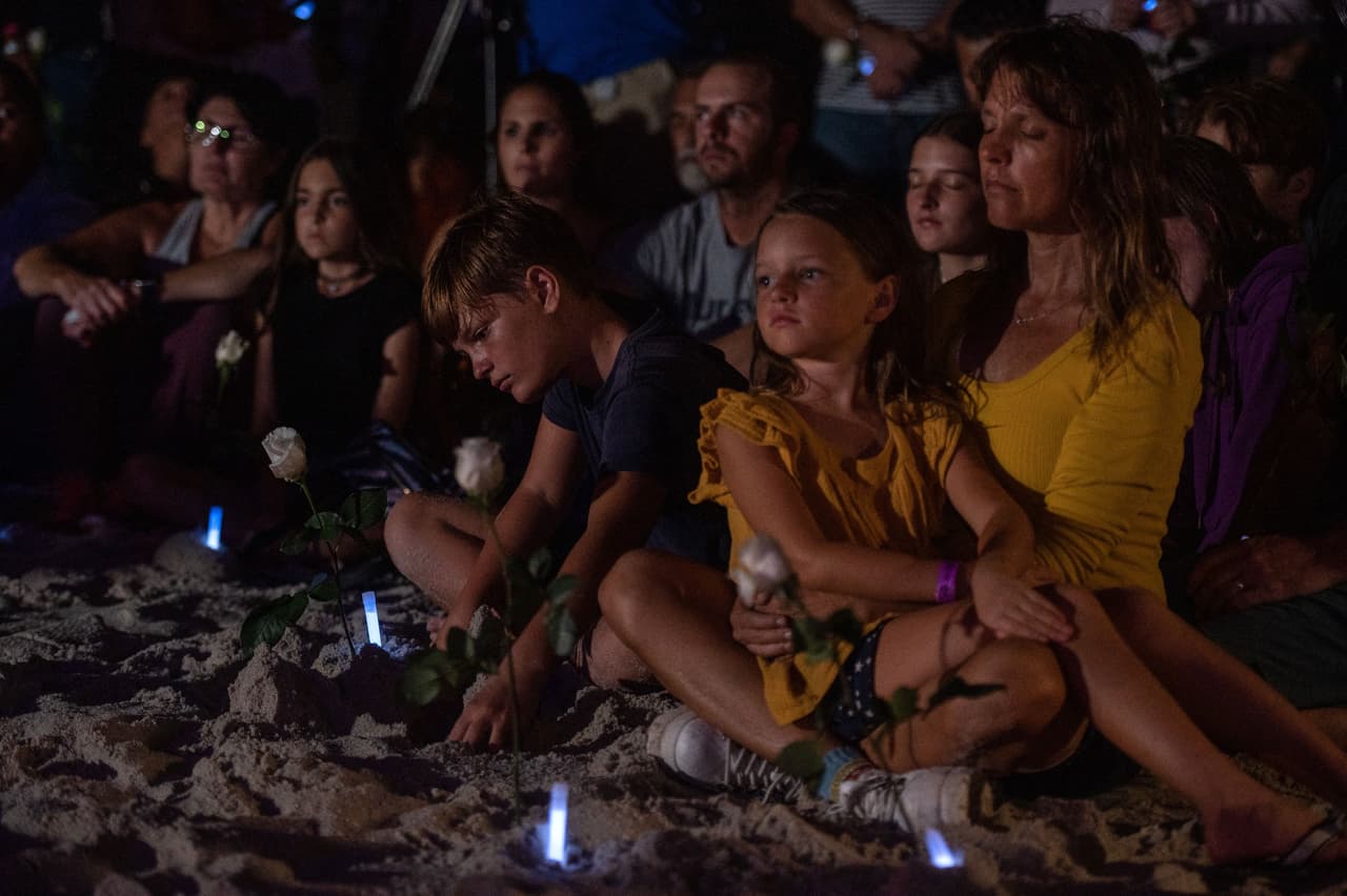 Muchos de los que participaron en la vigilia no pudieron contener las lágrimas. La gente sostenía en sus manos velas o flores. En el fondo se veían las grúas y a los rescatistas trabajando en el lugar del derrumbe. "
<a href="https://miami.cbslocal.com/2021/06/28/surfside-condo-collapse-vigil/" target="_blank">Todos estamos dolidos, esto ha sido duro.</a> Estamos tratando de dar un buen ejemplo para ser fuertes", dijo Derek Latta, vive en la zona, citada por CBS.