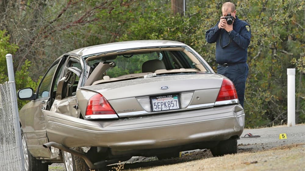 Un oficial de la Patrulla de Caminos de California fotografía un vehículo involucrado en el tiroteo.