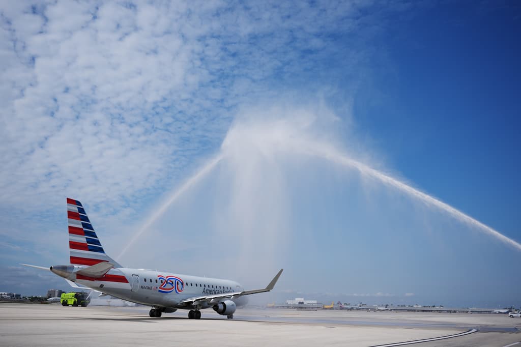 El vuelo AA3599 de American Airlines, el primer vuelo comercial directo entre Estados Unidos y Venezuela desde 2019, recibe un saludo con cañones de agua mientras se aleja de la puerta de embarque.