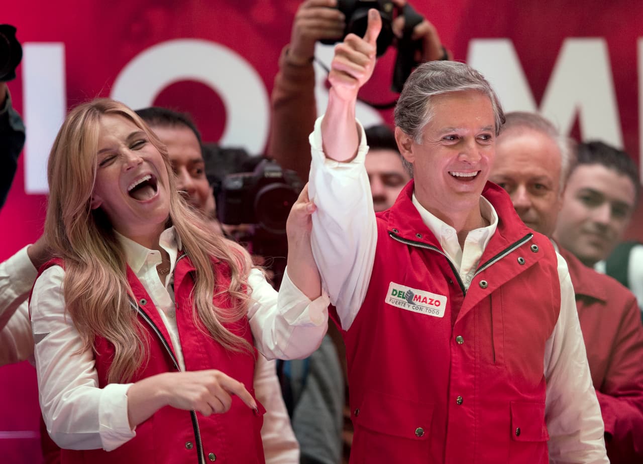 Alfredo Del Mazo, candidato a gobernador del estado de México por el Partido Revolucionario Institucional (PRI) y su esposa Fernanda Castillo saludan a los simpatizantes en la sede del partido en Toluca, capital del estado de México, el domingo 4 de junio de 2017. (AP Foto/Rebecca Blackwell)